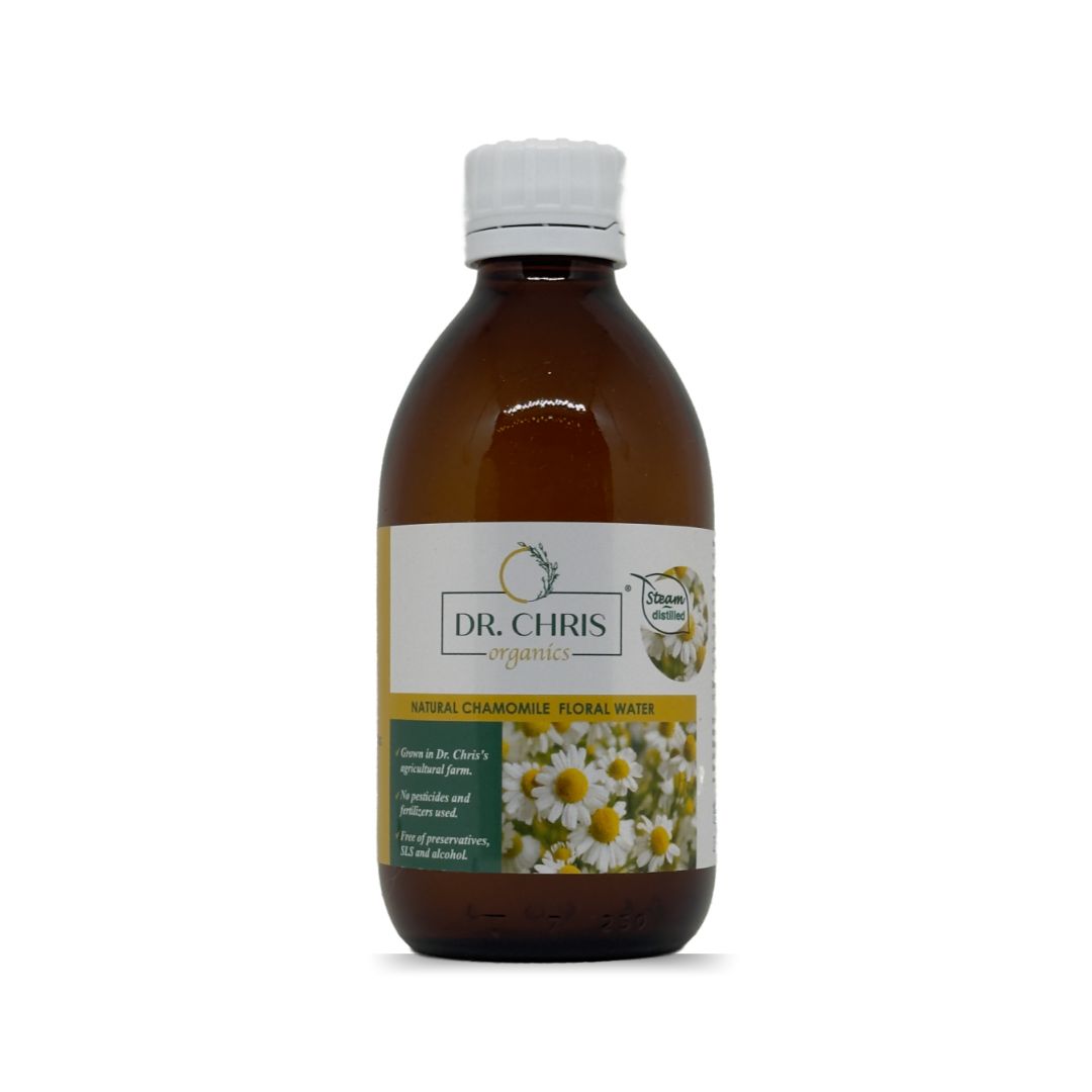 Product image of Chamomile Floral Water by Dr. Chris Organics, 250 ml. A clear glass bottle with a minimalist label, featuring natural chamomile illustrations. The product is organic and designed for soothing and refreshing skincare.